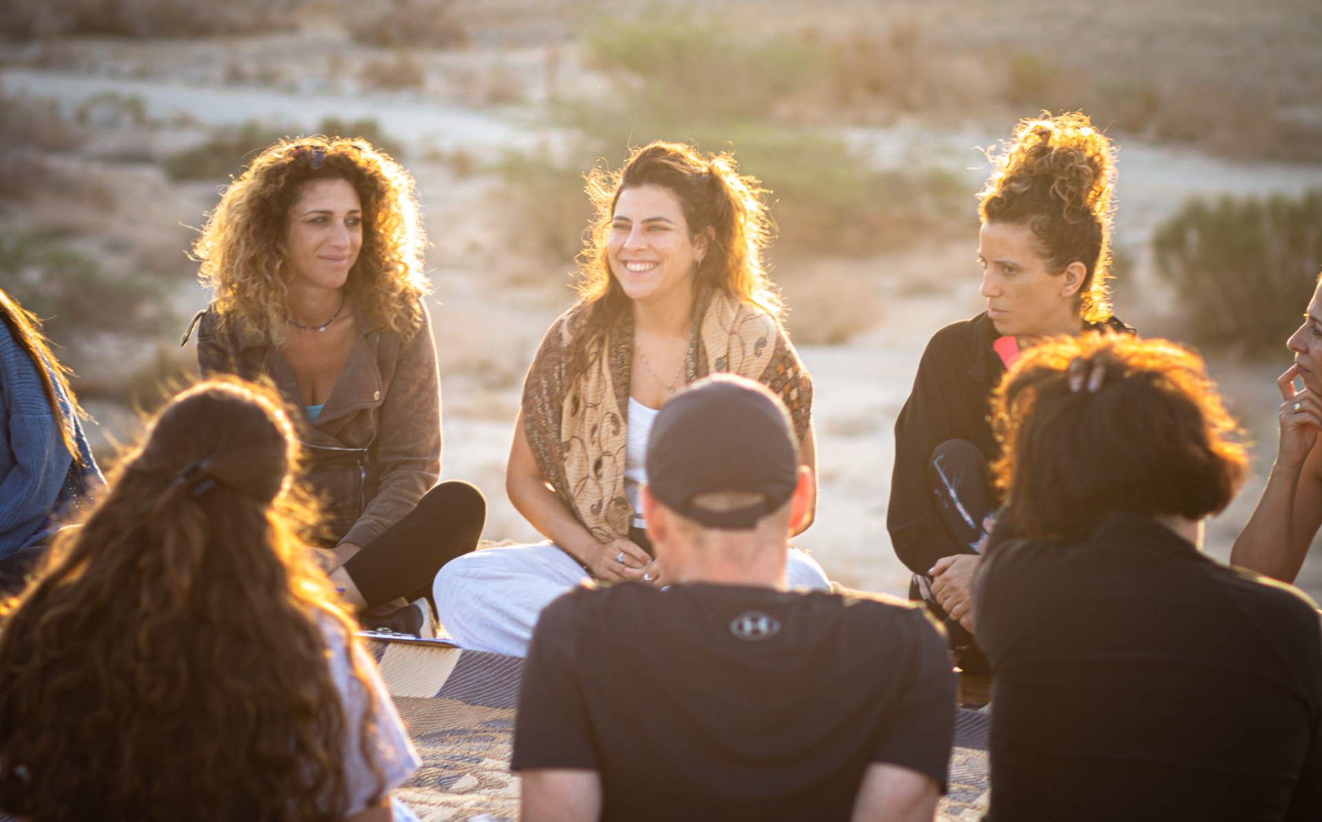 A sharing circle gathered outdoors in golden afternoon light