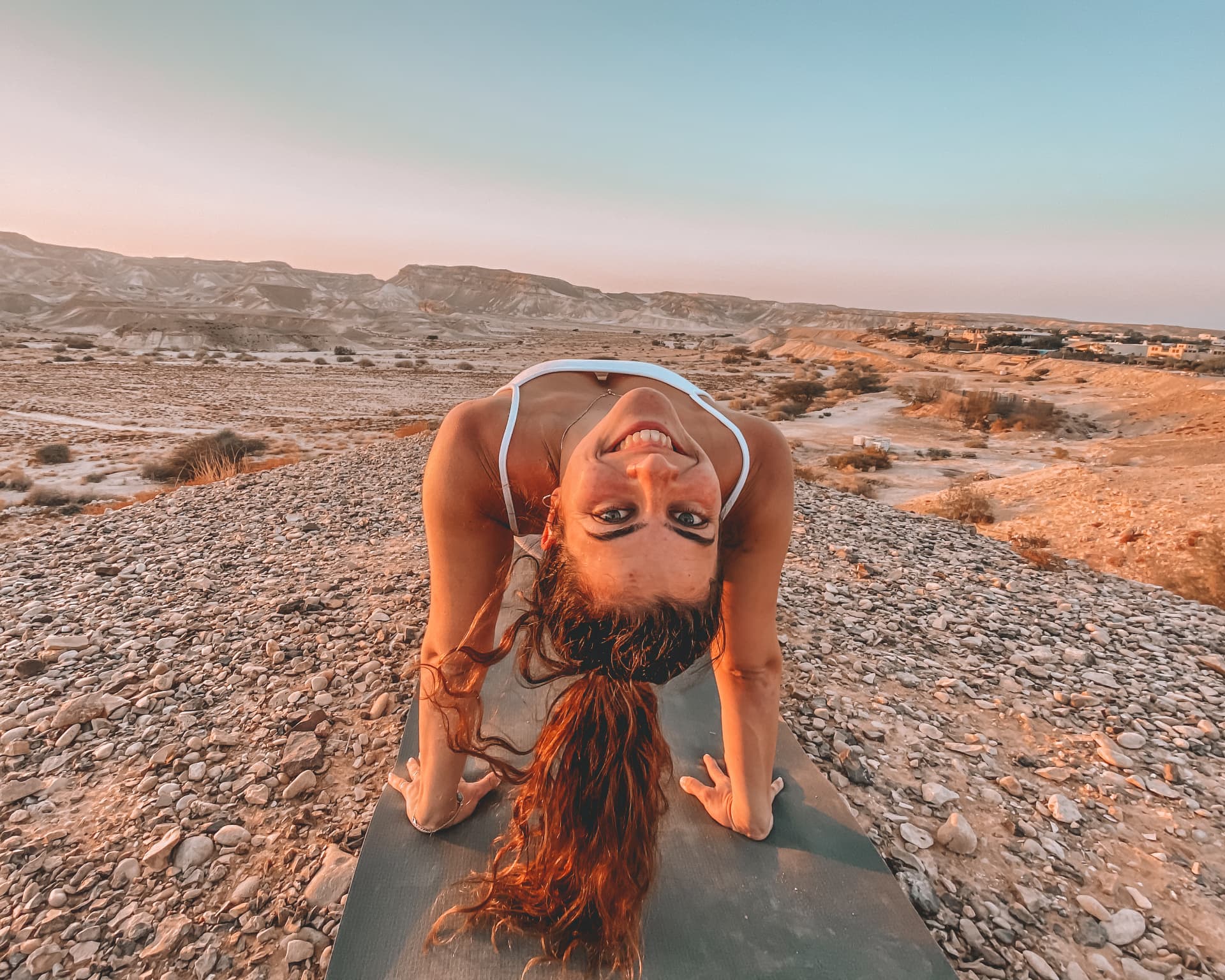 Michal in a backbend on her mat in the desert at sunrise